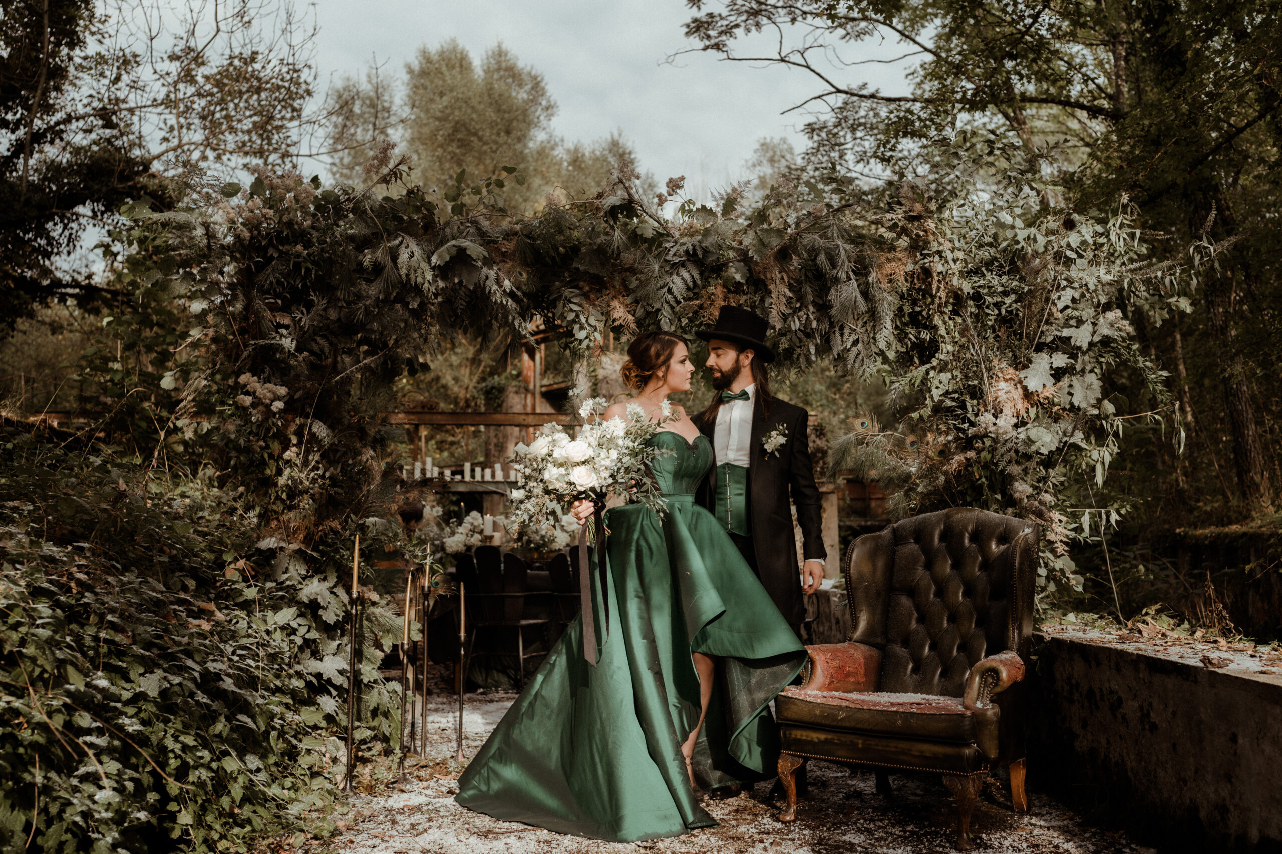 Dans le parc d’une riche demeure, que l’on voit à gauche de l’image, on aperçoit à travers une bulle géante deux silhouettes tout occupées à la création de bulles. Plume et Grelot sont vétus de blanc : pantalon bouffant, chemise et chapeau haut-de-forme pour Grelot ; jupe ample, jupon, petit haut et boléro pour Plume. Image issue de l’animation participative et contemplative Plume et Grelot de la Cie Médusa (Grenoble). 